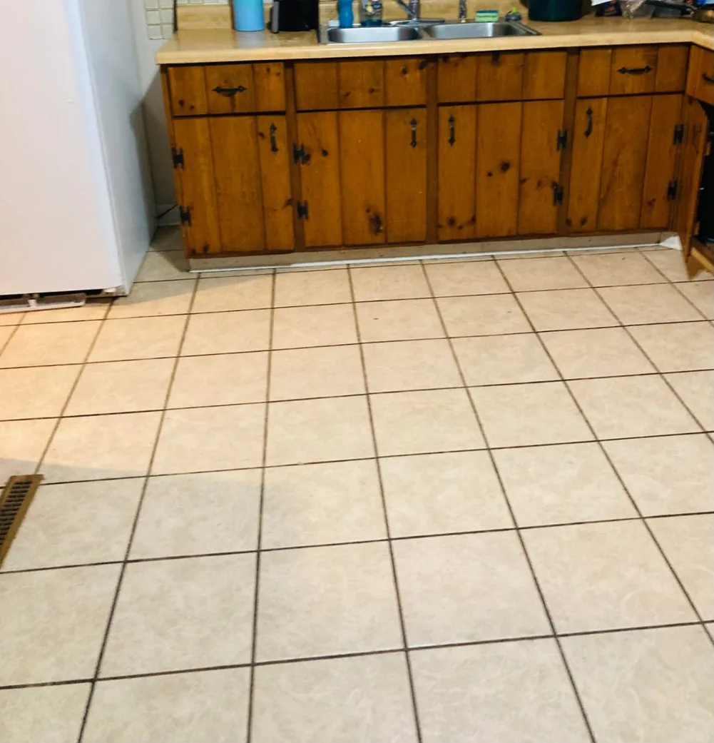 Light tile flooring, wood cabinets, and sink wall in a residential interior
