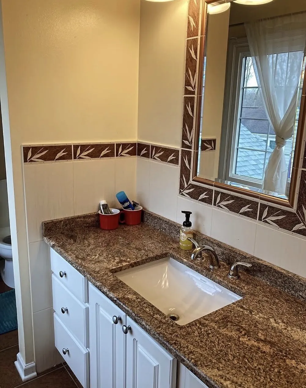 Vanity with mirror, soap dispenser, and organized countertop