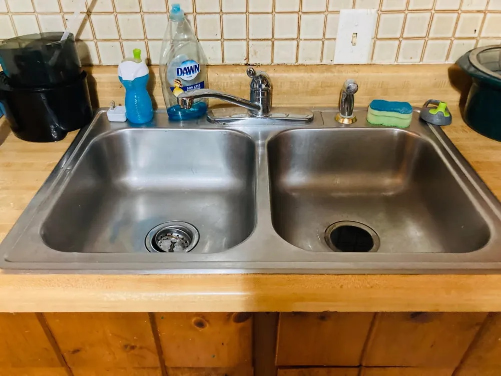 Double-bowl stainless basin and laminate worktop under natural light
